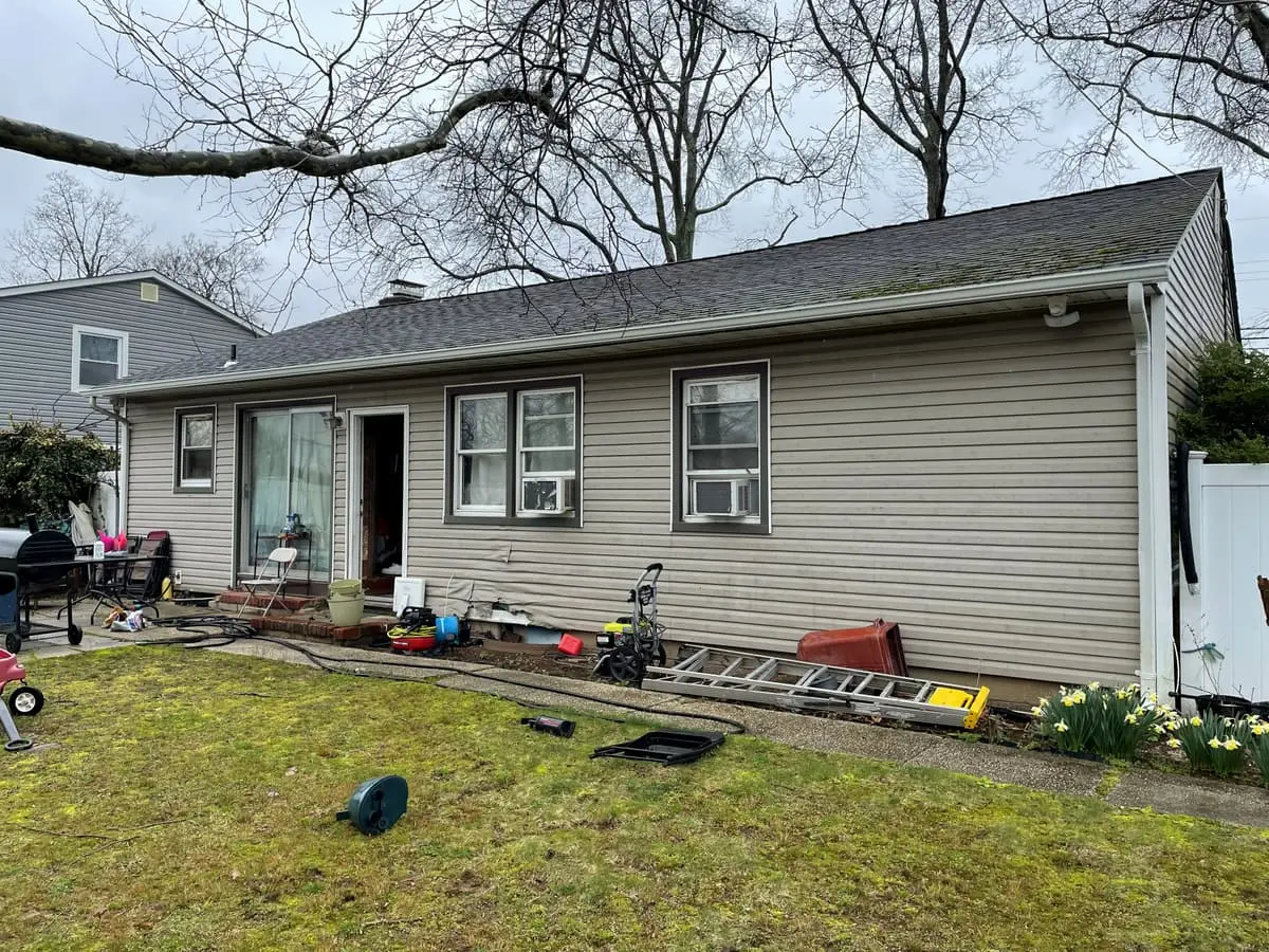 Selling a house during a divorce in Amityville: back of a ranch with a ladder on the lawn
