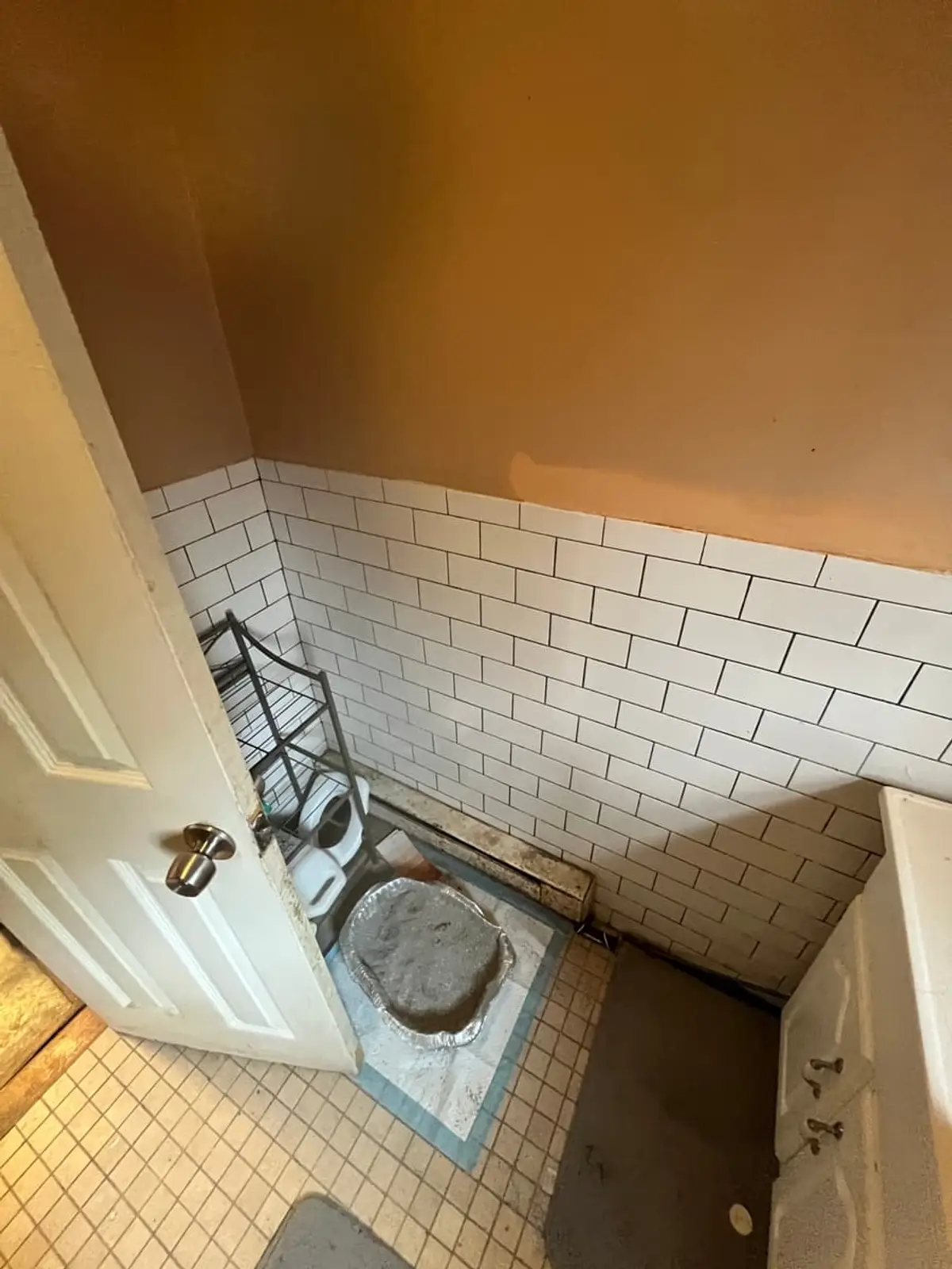 Selling a house after a life change in Amityville: bathroom floor with the toilet pulled out