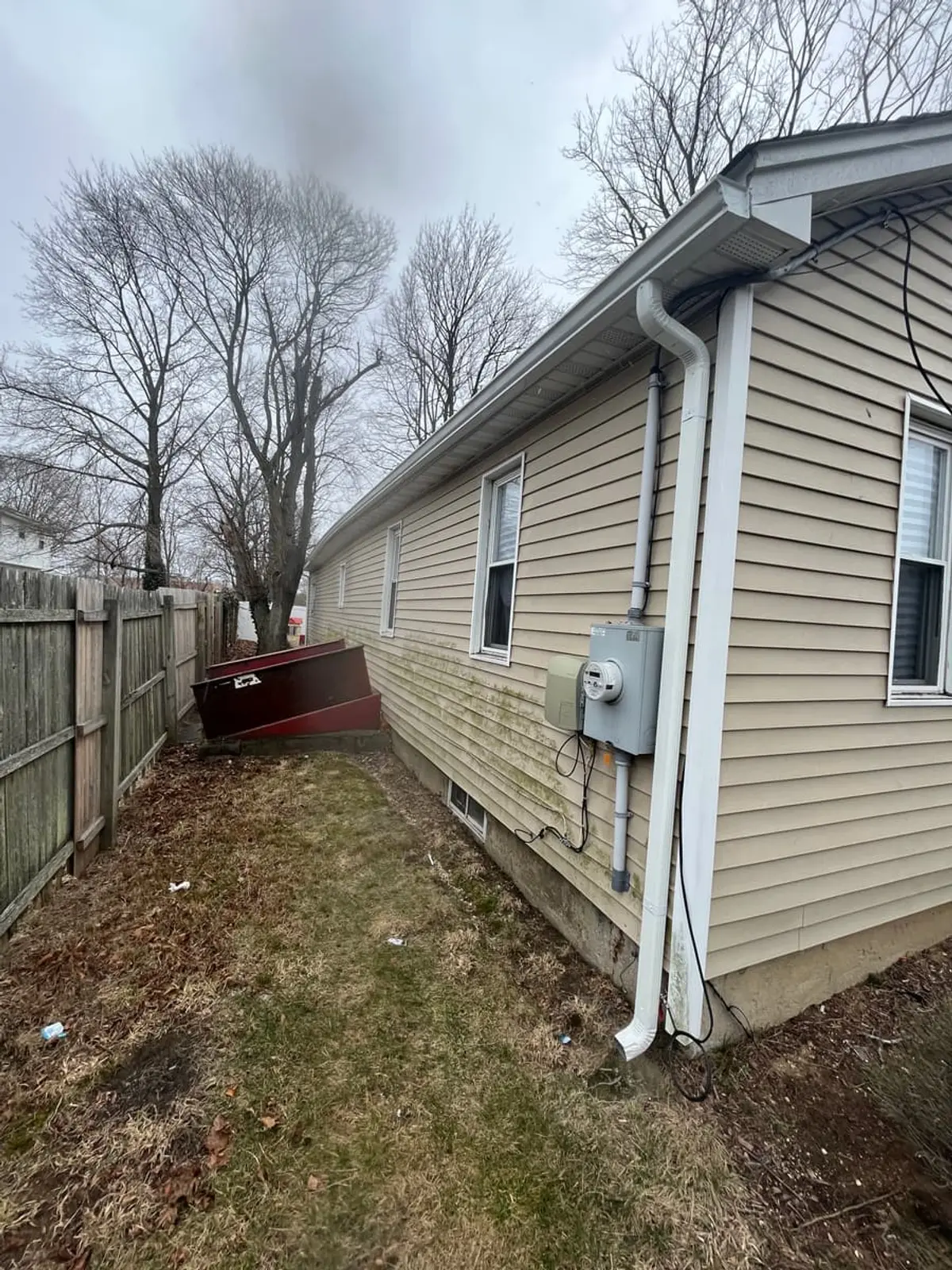Downsizing or retiring in Amityville: side yard with a basement bulkhead and old fence