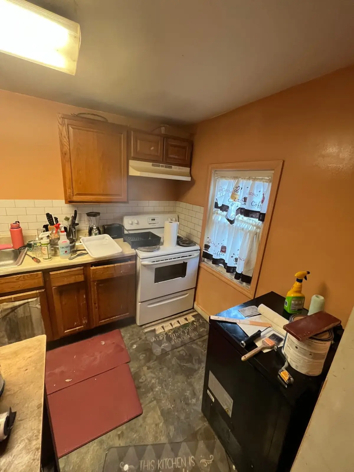 Selling a parent’s house after a move to care in Amityville: small kitchen with oak cabinets and a white stove